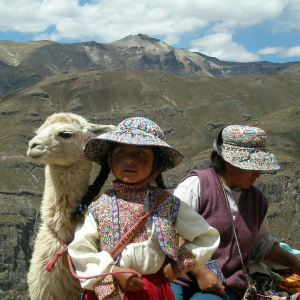 FOTOGRAFIA CON BAMBINA, LAMA BIANCO E DONNA CON SFONDO LE MONTAGNE DEL PERU'